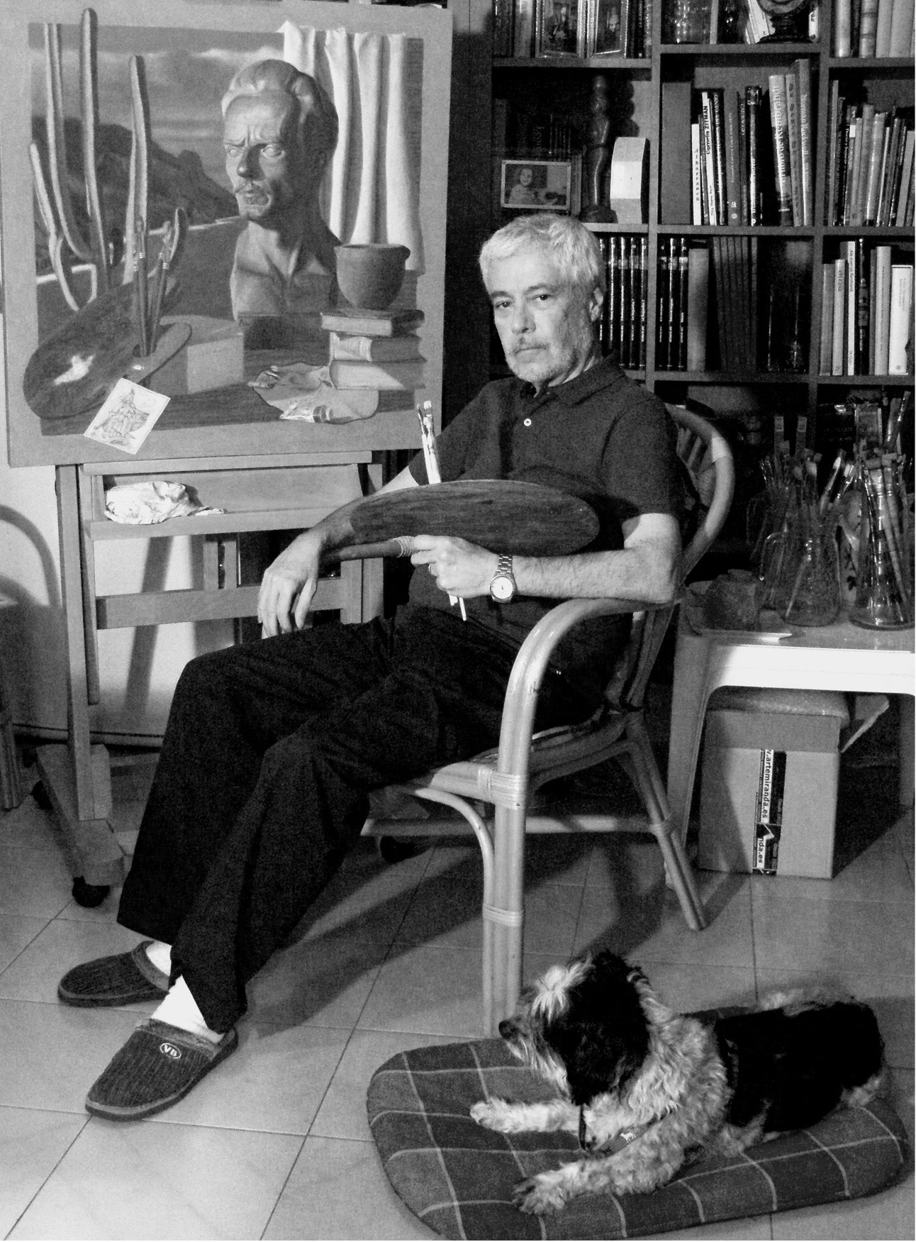 Juan Luis Torres Román en su estudio de Alicante, junto a una de sus obras y acompañado por Milo